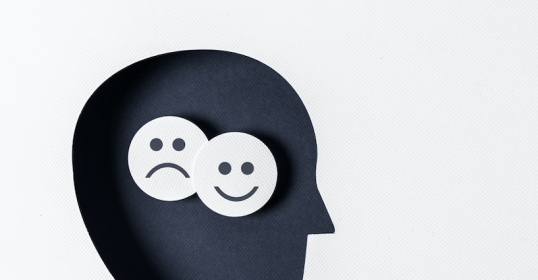 A man's head with two smiley faces, activating his brain.