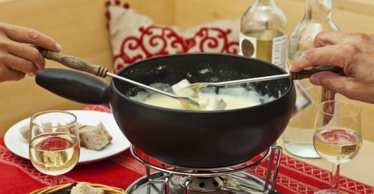 Create a romantic at-home fondue date with a fondue pot on the table.