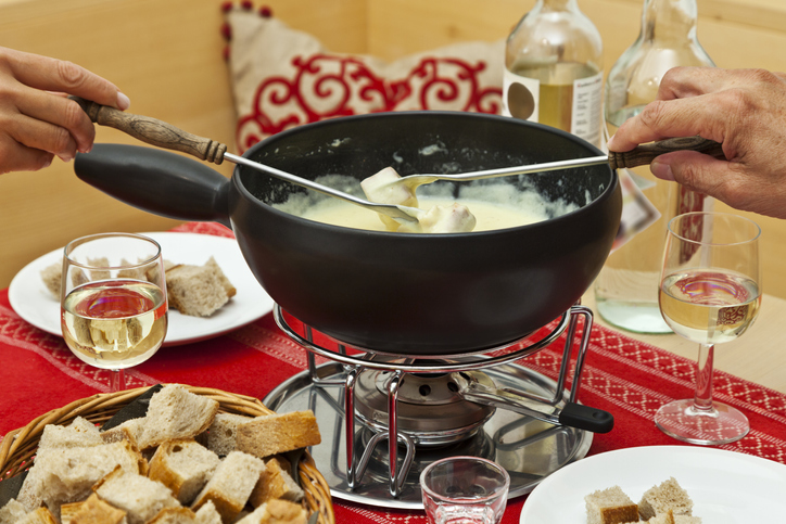 Create a romantic at-home fondue date with a fondue pot on the table.