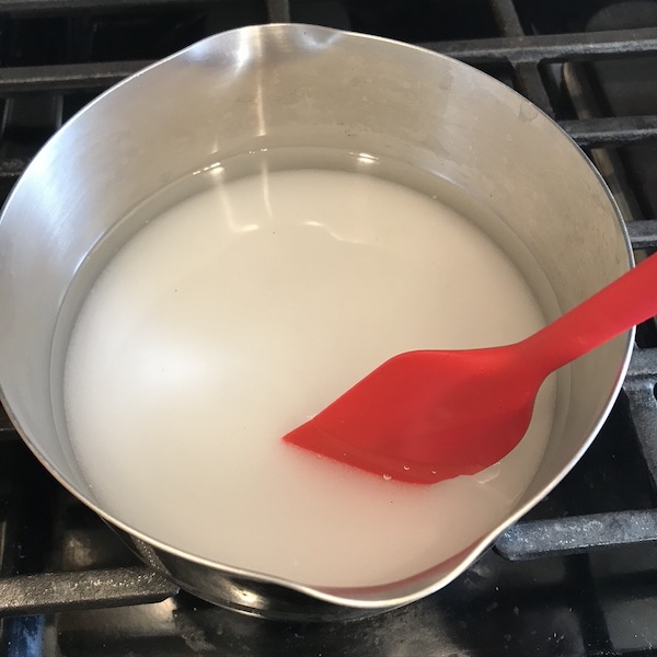 Syrup in a pot with spoon. 