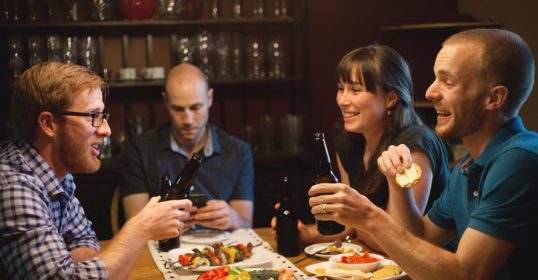 A group of people sitting around a table, sharing stories.
