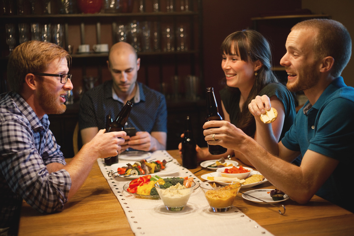 A group of people sitting around a table, sharing stories.