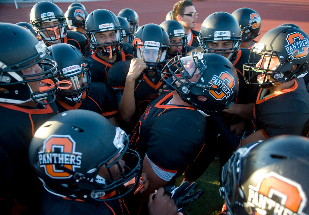 A group of boys in a huddle, preparing for the game with sportsmanship and ferocity.