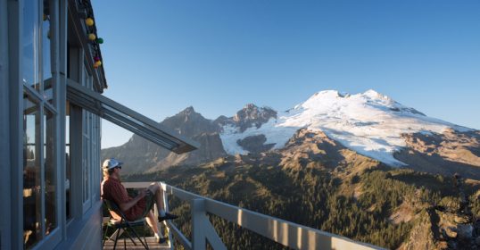 A person sitting on a wooden deck, off the grid.