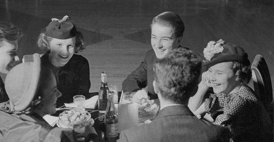 A group of women with good manners sitting around a table.