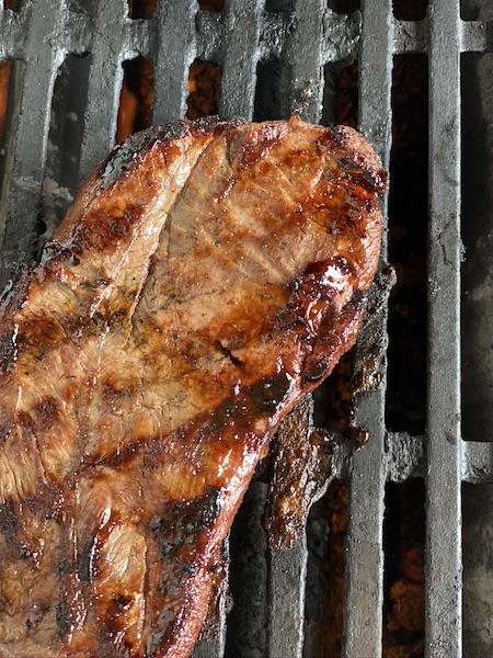 Steak getting grilled over medium high heat.