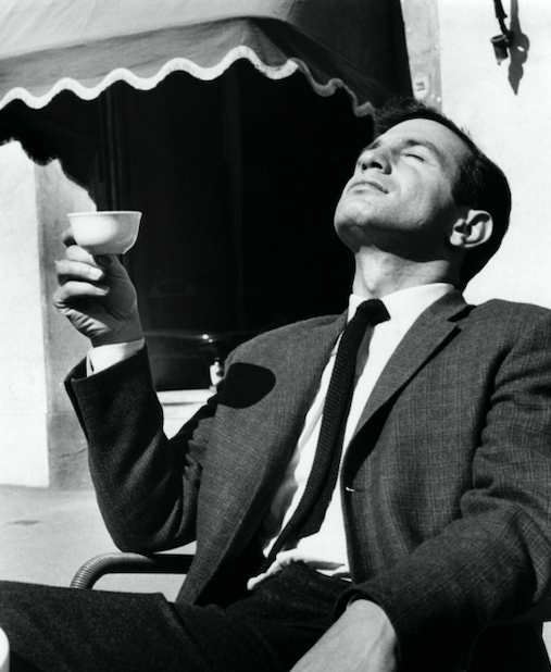 Man holding a cup and enjoying sunlight.