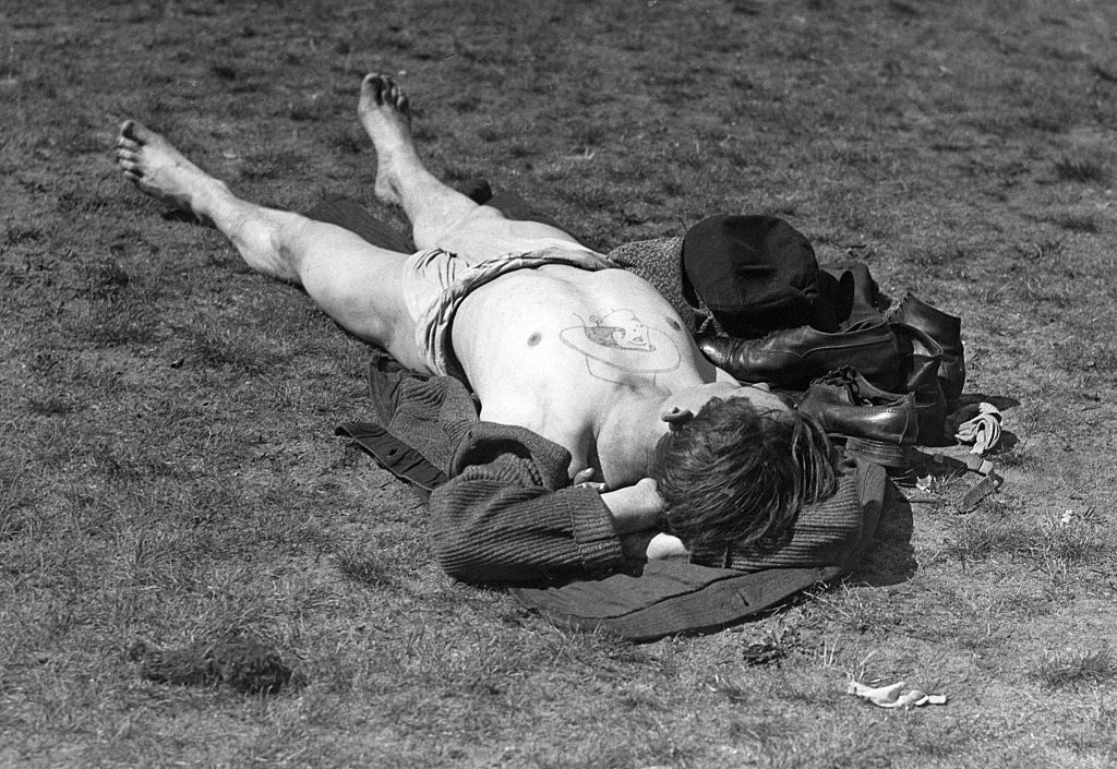 Man laying on the ground for absorbing sunlight.