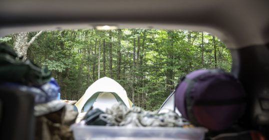 A car with a tent in the back seat is essential for car camping.
