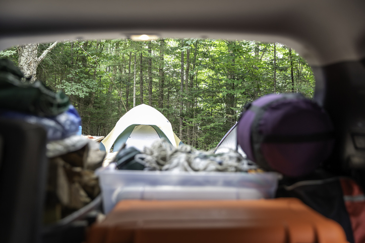 A car with a tent in the back seat is essential for car camping.