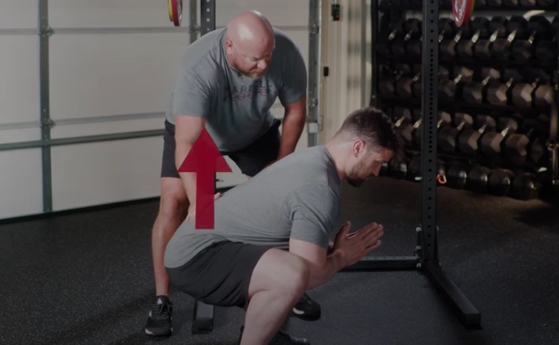 Um homem a fazer exercício com o seu instrutor de ginástica.