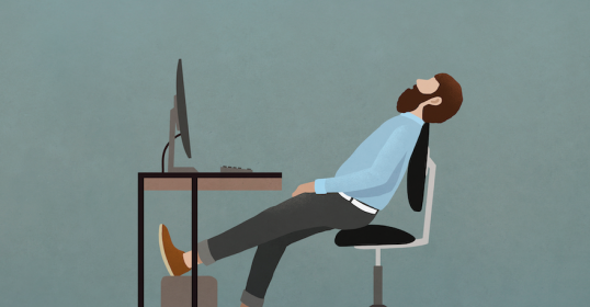 A man sitting at a desk while working from home with his legs crossed.