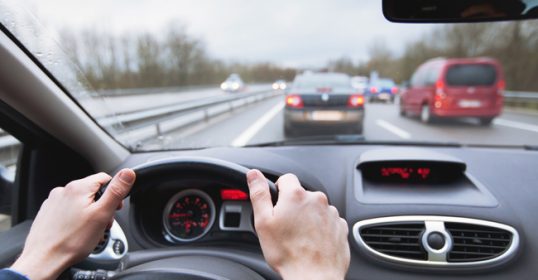 A person practicing defensive driving on a highway.