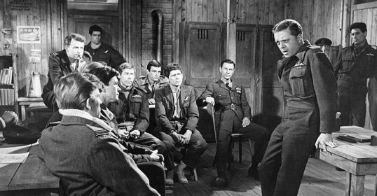 A group of men in uniform sitting around a table during the Great Escape.