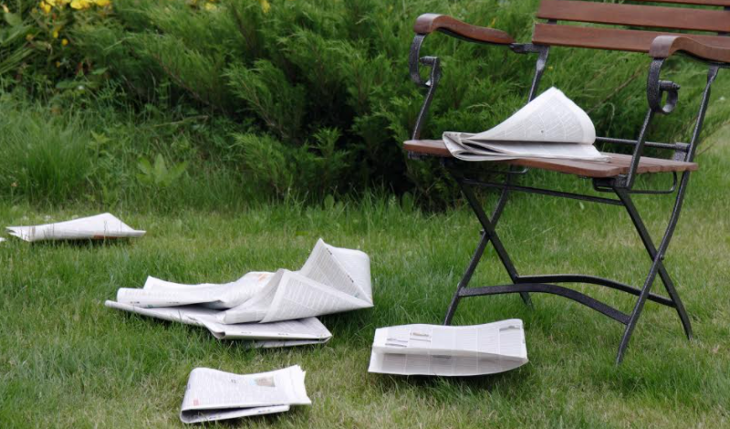 .  A chair covered in newspapers on the grass, recalling historic times.