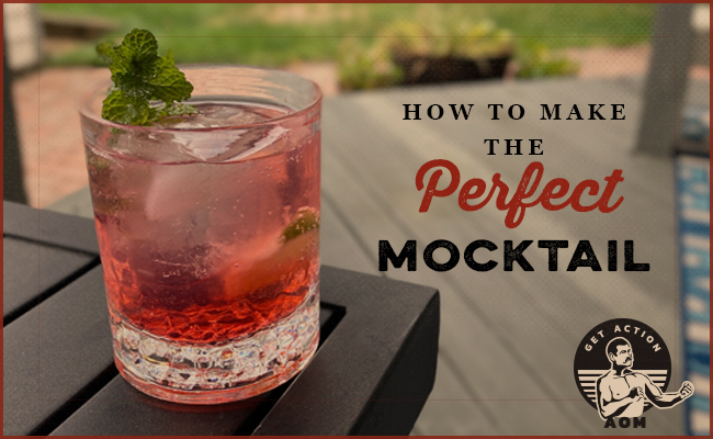 mocktail with red color and mint sprig on a patio table.