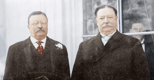 Two men in suits standing next to each other, reflecting on a lesson.