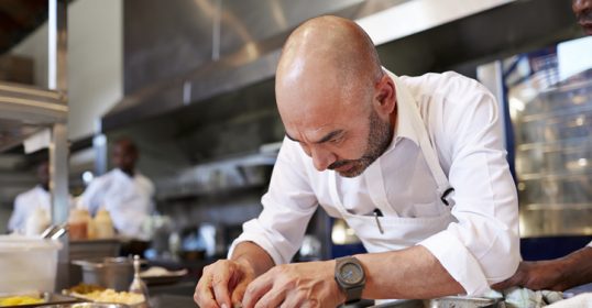 A chef in the kitchen, organizing food.