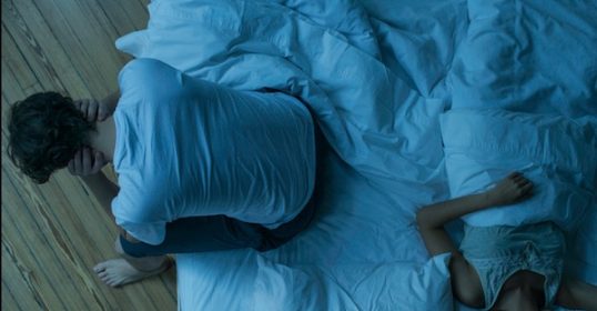 A man and woman are resting on top of each other in bed, seeking better sleep.