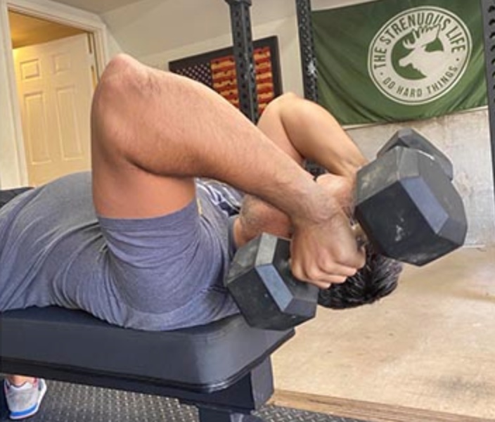 A man on a bench doing Tricep Extensions with dumbbells, demonstrating Bro Basics.