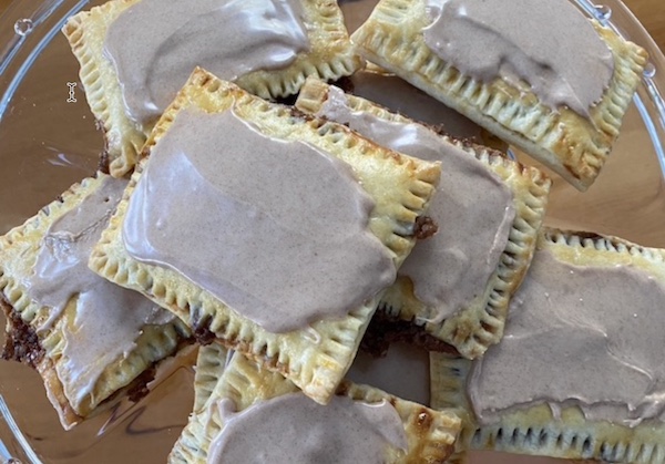 A plate of homemade pastries with chocolate icing on top.