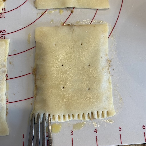 crimping edges of homemade pop tarts with fork. 