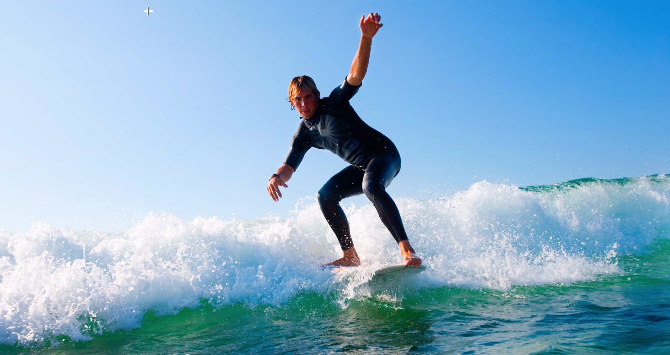 A man in a wetsuit gracefully rides a wave on a surfboard, embodying the thrill of learning new skills.