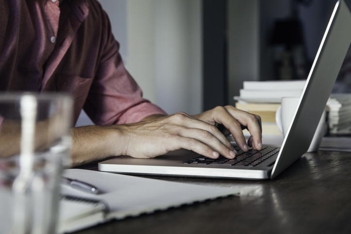 A man writing on a laptop.