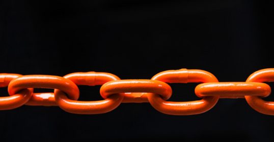 An orange chain on a black background represents the process of breaking habits.
