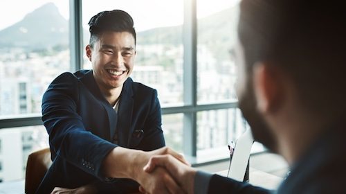 Two businessmen shaking hands in the office.