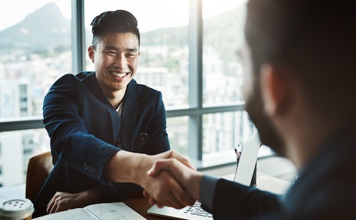 Two businessmen shaking hands in the office.