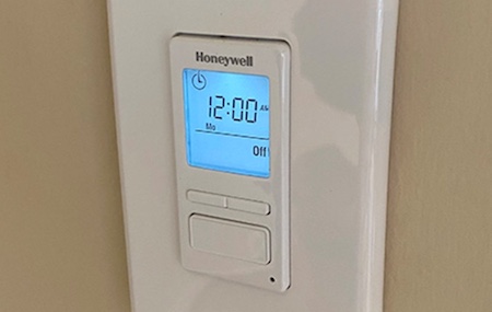A Honeywell programmable timer is mounted on a wall.