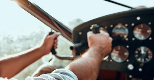 A man is in the cockpit of a plane, taking responsibility for the controls.