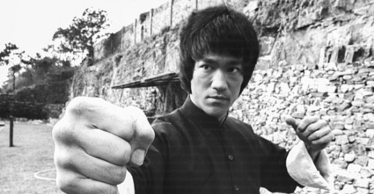 Bruce Lee, with his fist in the air, embodies a powerful life philosophy.