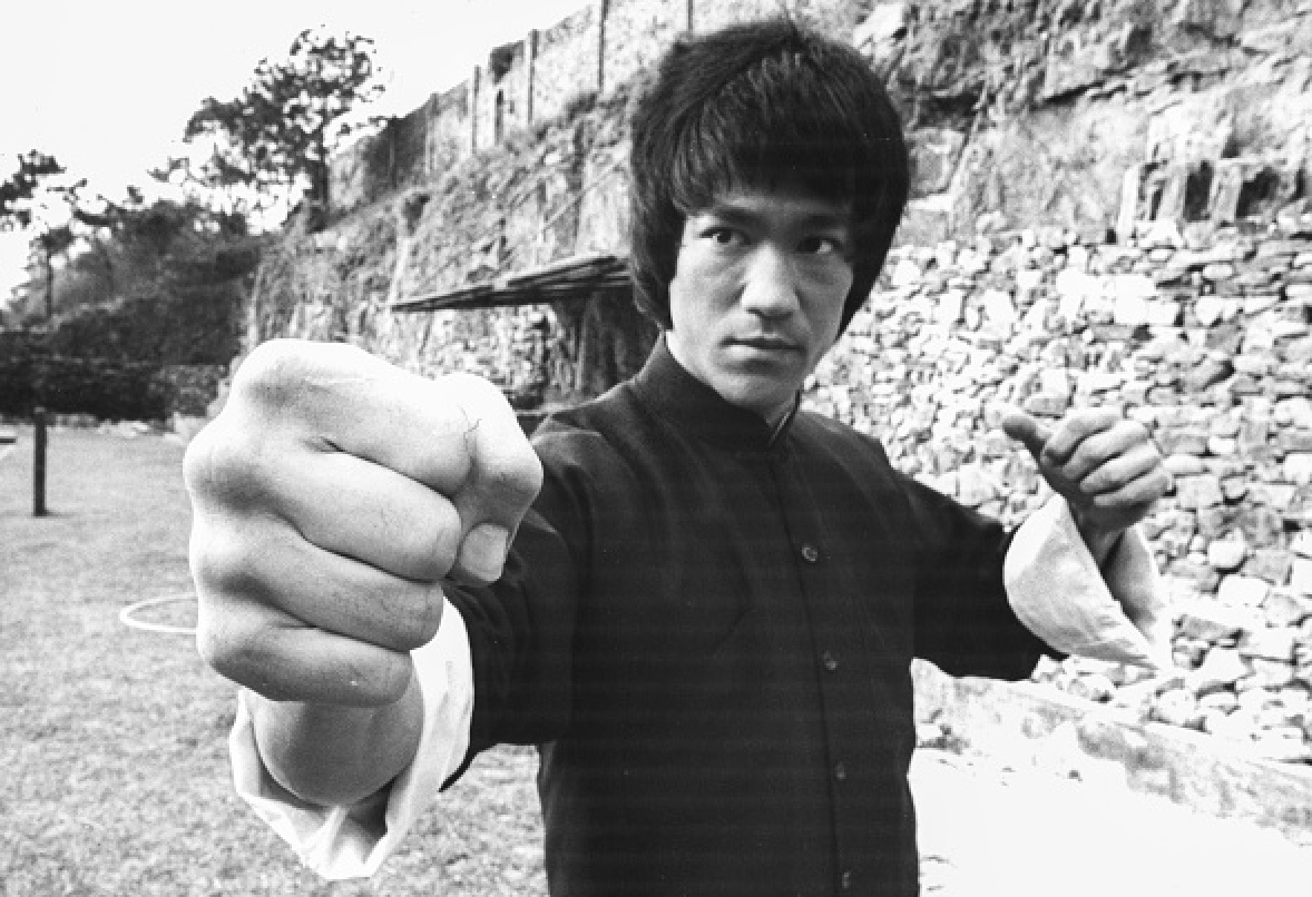Bruce Lee, with his fist in the air, embodies a powerful life philosophy.