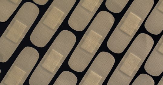 A close-up of a bandage on a black background.