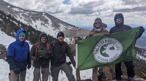 In May 2021, a group of people conquered a mountain peak, proudly waving a green flag.