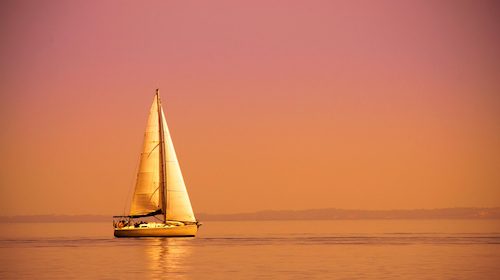 A sailboat on the water at sunset makes your life relaxing and effortless.