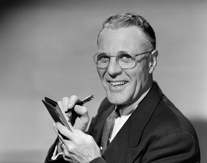 A black and white photo of a man holding a pen, showcasing his power.