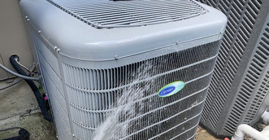 A person is spraying water on an air conditioner in the house.