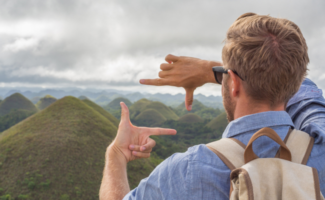 On a Sunday Firesides, a Me is pointing at the chocolate hills in Bohol, Philippines.