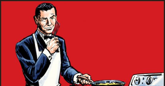 A man in a tuxedo cooking scrambled eggs on a stove.