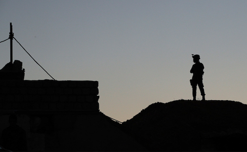 A man standing on top of a roof, contemplating his next move.