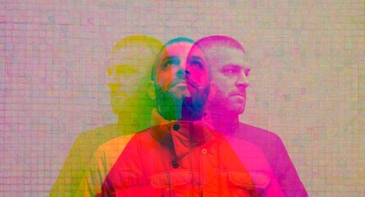 A photo of a man and a woman standing in front of a brick wall.