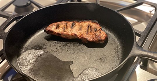 The best way to reheat steak is by using a frying pan on a stove.
