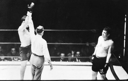 A black and white photo of two boxers in a boxing ring captures the intensity of the match.