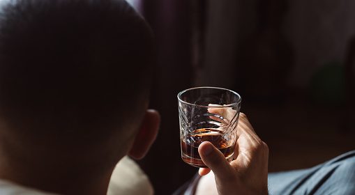A man drinking whiskey.