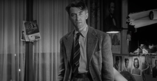 A desperate man in a suit standing in a room.