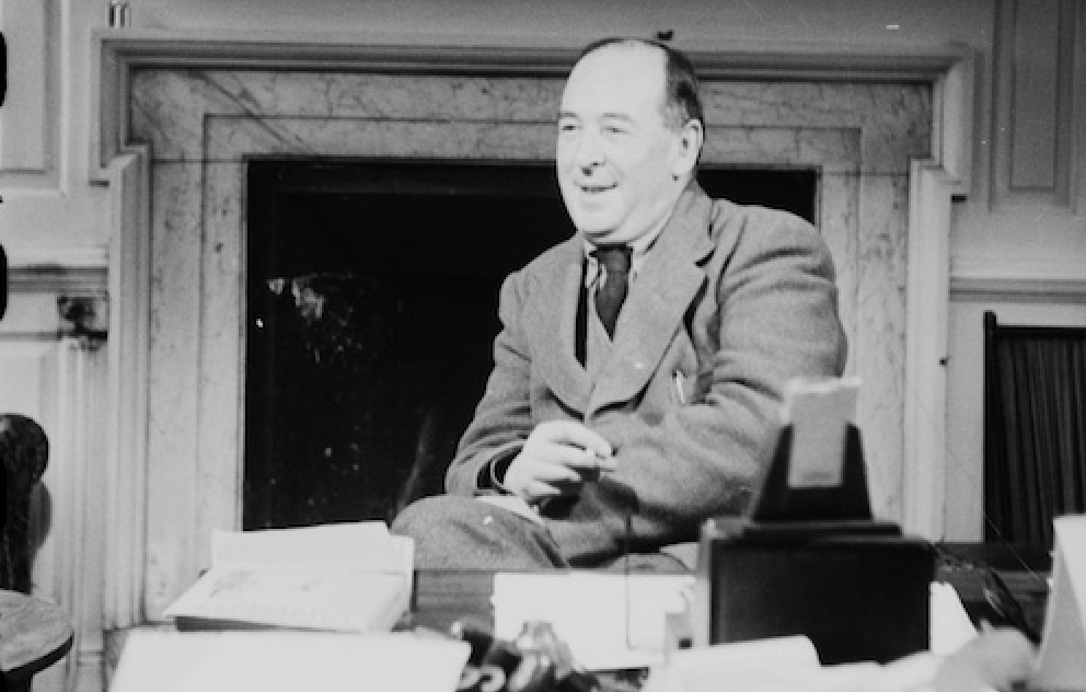 An old black and white photo of a man sitting at a C.S. Lewis desk.