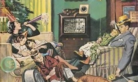 A family sitting on a couch watching TV in 2021.